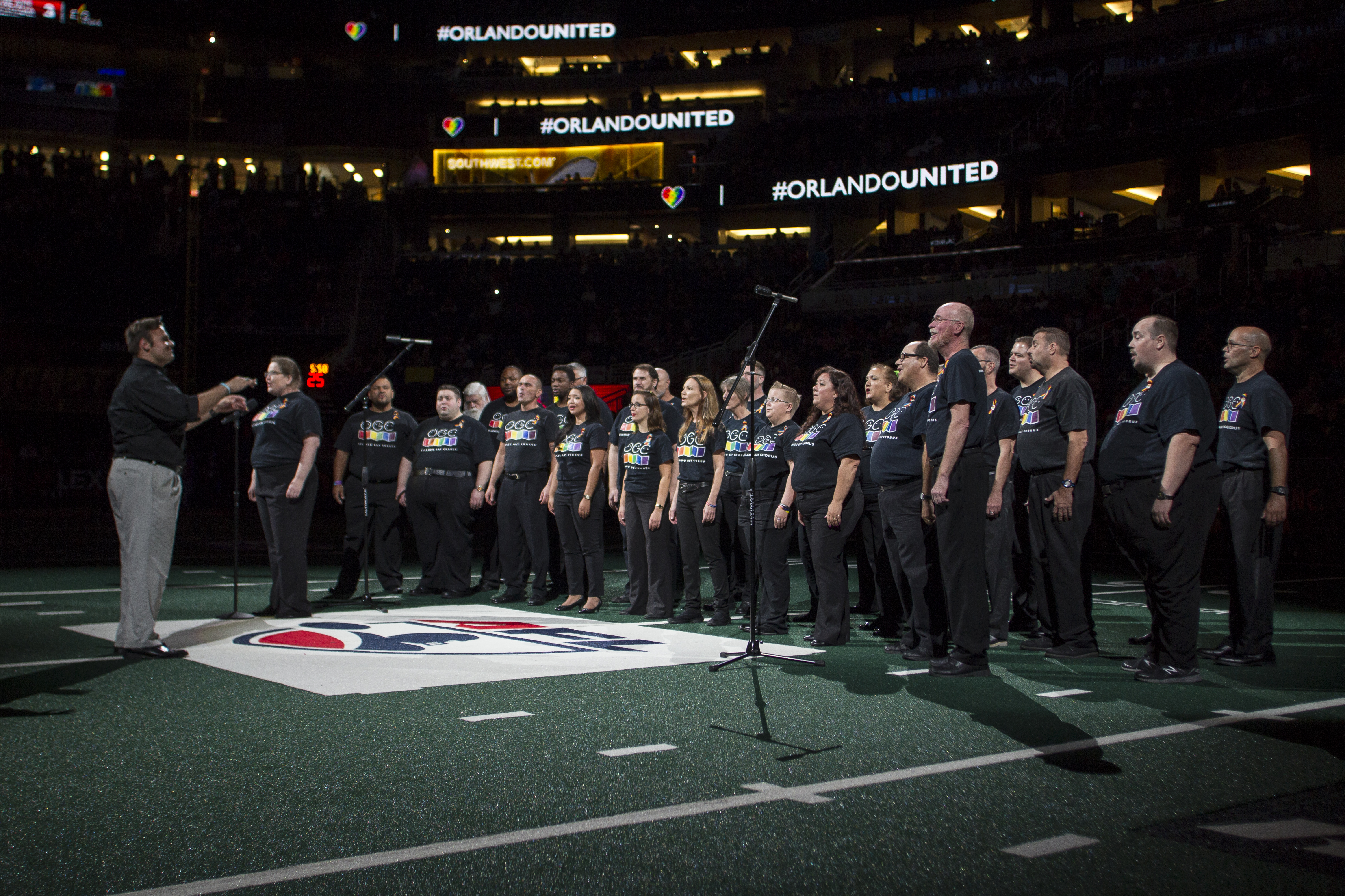 Coro cantando en el medio de un estadio