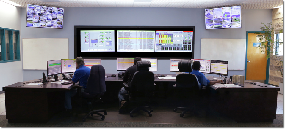Photo of 3 people sitting behind computers at a command center